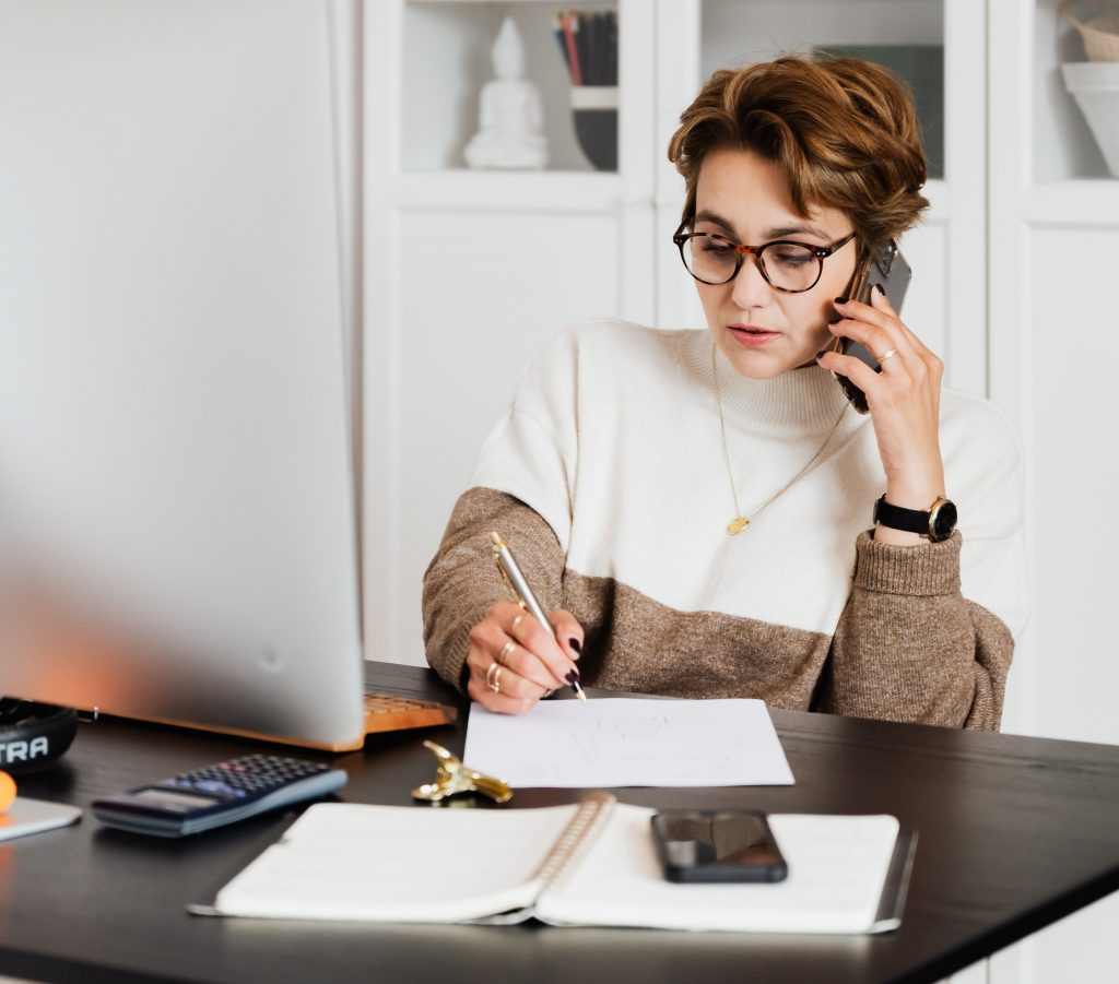 Woman note-taking. Image represents questions being asked when choosing a nanny or housekeeper agency.